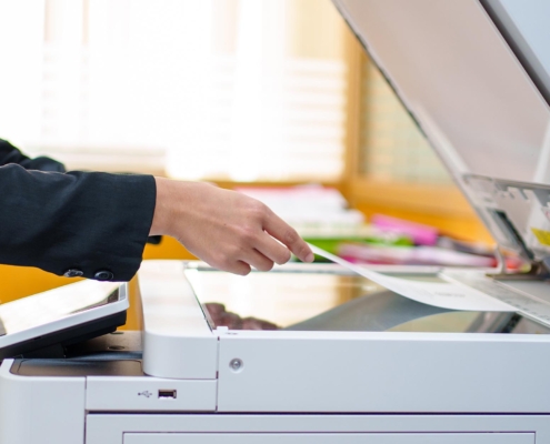 Office worker laying papers on copy machine