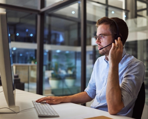 Tech professional helping client with computer